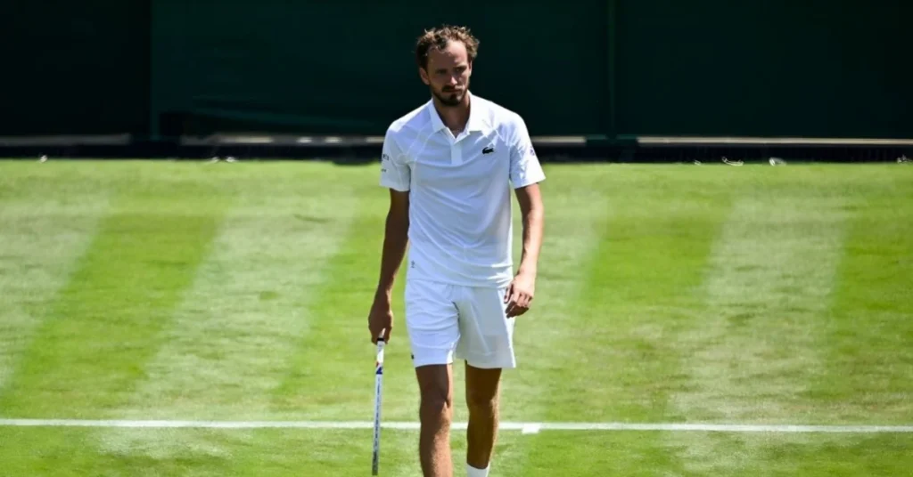 a man in white shirt and shorts holding a tennis racket